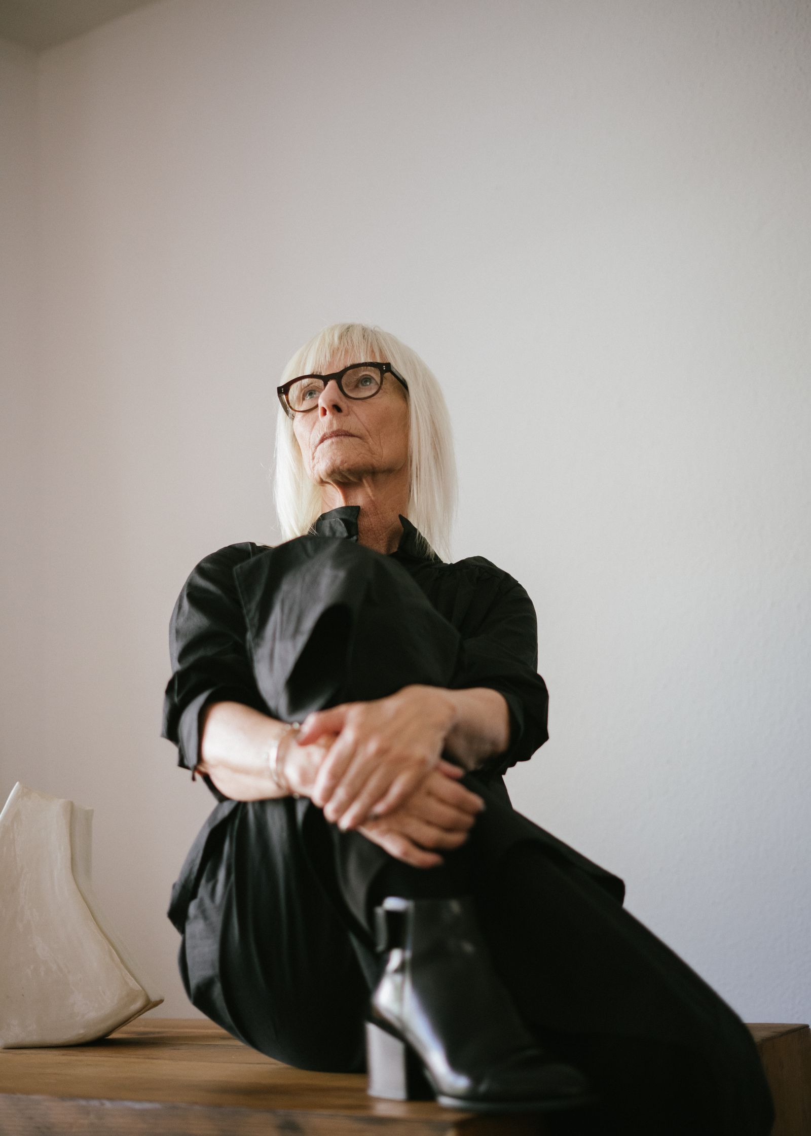 An older woman sitting quietly, looking away from the camera